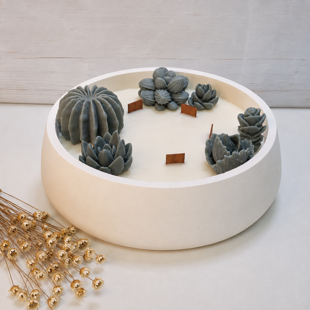 Vela aromática artesanal grande en recipiente blanco decorado con cactus y suculentas