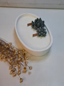 Vela ovalada artesanal blanca en resina ecológica con mechas de madera